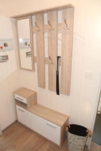 een kast met een houten plank en een spiegel bij Nimo III in Norddeich