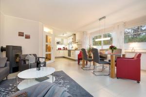a living room with a table and chairs and a kitchen at Haus ZingstZeit in Zingst