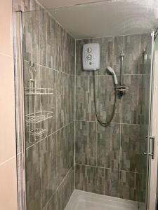 baño con ducha y puerta de cristal en HAMS LODGE - - Strictly Only ONE GUEST ALLOWED IN ONE ROOM A SECOND ACCOMPANYING PERSON WILL NOT BE ALLOWED INTO THE PROPERTY, en Birmingham