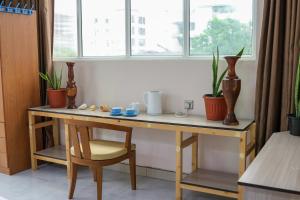 a wooden table with plants on it next to a window at Green Vista Maafushi in Maafushi