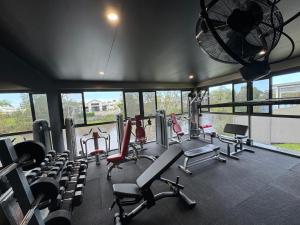 a gym with lots of cardio equipment and windows at Lakeside Retreat in Gold Coast