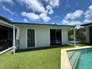 a house with a yard with a swimming pool at Lakeside Retreat in Gold Coast