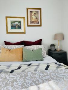 ein Schlafzimmer mit einem Bett mit zwei Bildern an der Wand in der Unterkunft Merrett Vale Home in Moss Vale