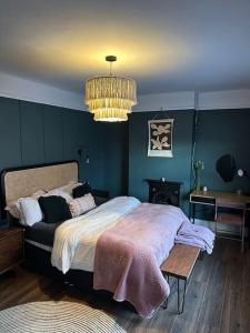 1 dormitorio con cama y lámpara de araña en Ivy Villa en Trench