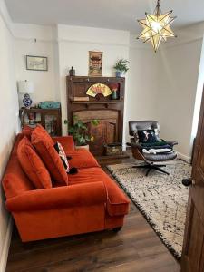 a living room with an orange couch and a chair at Ivy Villa in Trench