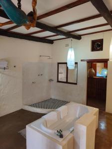 a large white bath tub in a room at Dar Amane Guest House in Graskop