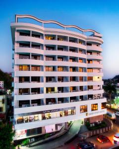 um edifício alto e branco com carros numa cidade em Gold Crest Hotel em Mwanza