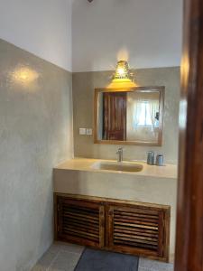 a bathroom with a sink and a mirror at Nyumbani Tamu in Watamu