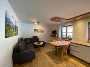 ein Wohnzimmer mit einem Sofa und einem Tisch in der Unterkunft Hemerhof in Oberstdorf