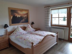 ein Schlafzimmer mit einem Bett mit einem Bild an der Wand in der Unterkunft Hemerhof in Oberstdorf