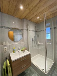 ein Badezimmer mit einer Dusche, einem Waschbecken und einer Badewanne in der Unterkunft Hemerhof in Oberstdorf