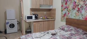 een kleine kamer met een bed en een magnetron bij ART 2 in Sliven