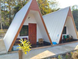 a small house with a triangular roof at Nam Hu Camping น้ำฮูแคมป์ปิ้ง in Chiang Dao