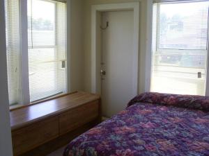 a bedroom with a bed and a dresser and two windows at Crestview Inn in Crestview