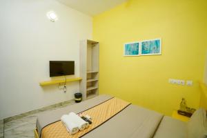 a bedroom with a bed with a television and towels at Twinn Waves Calicut in Kozhikode