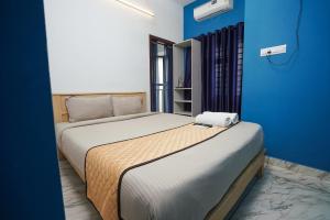 a bedroom with two beds and a blue wall at Twinn Waves Calicut in Kozhikode