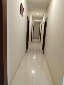 a long hallway with doors and a tile floor at Hotel Raipur Pride in Raipur
