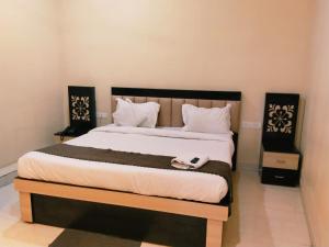 un lit avec un téléphone installé au-dessus dans l'établissement Hotel Raipur Pride, à Raipur