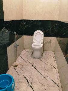 La salle de bains est pourvue de toilettes et d'un sol en marbre. dans l'établissement Hotel Raipur Pride, à Raipur