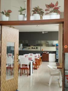 une salle à manger avec des tables et des chaises blanches dans l'établissement Hotel Raipur Pride, à Raipur