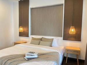 a bedroom with a bed with two books on it at Arom Pool Villa Pattaya 2 in Na Jomtien +30 photos