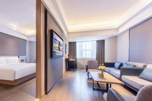 una camera d'albergo con letto e soggiorno di Atour Hotel Chongqing North Railway Station a Chongqing