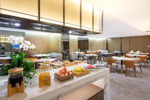 a restaurant with food on a counter with tables and chairs at Atour Hotel Shenzhen Luohu Diwang in Shenzhen