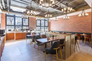 a restaurant with tables and chairs and brick walls at Atour X Hotel Beijing Daxing Airport Wildlife Park in Daxing