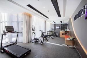 een fitnessruimte met een loopband en fitnessapparatuur in een kamer bij Atour Hotel Shenzhen Nanshan Xili University Town in Shenzhen