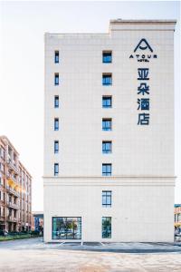 un edificio blanco con un cartel. en Atour Hotel Hangzhou Zhuantang Songcheng Academy of Fine Arts, en Hangzhou