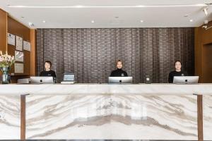 three people sitting at a table with laptops at Atour Hotel Hangzhou Huanglong in Hangzhou