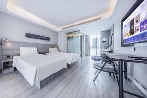 a hotel room with two beds and a flat screen tv at Atour Light Hotel Beijing Daxing Biomedical Base Metro Station in Daxing