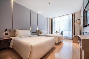 um quarto de hotel com duas camas e uma televisão em Atour Hotel Shenzhen Baoan Xixiang em Bao'an