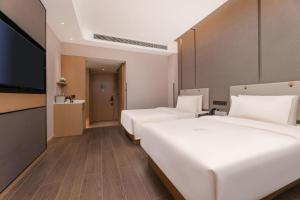 a hotel room with two beds and a flat screen tv at Atour Hotel Zhijiang Bridge in Hangzhou +46 photos