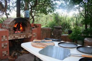 a table with a grill and a fire oven at Kiburi Lodge @ Kruger, a secluded Bushveld getaway in Marloth Park