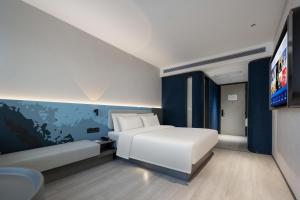 a bedroom with a white bed and a flat screen tv at Atour Light Hotel Guangzhou East Fuhua Road Panyu Plaza in Guangzhou