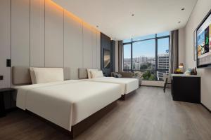 a hotel room with two beds and a large window at Atour Hotel Foshan Chancheng Zhangcha in Foshan