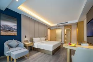 une chambre d'hôtel avec un lit et une chaise dans l'établissement Atour X Hotel Shenzhen Baoan Airport Aviation City, à Bao'an