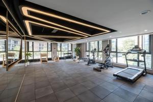 - une salle de sport avec tapis de course et vélos elliptiques dans une pièce dotée de fenêtres dans l'établissement Atour Hotel Hangzhou Qianjiang Century City International Expo Center, à Xiaoshan