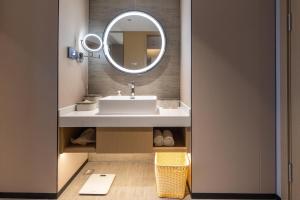a bathroom with a sink and a mirror at Atour Hotel Zhongshan Nantou Haiya Colorful City in Zhongshan +13 photos