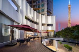 a balcony of a building with tables and chairs at Atour Light Hotel Guangzhou Pazhou Exhibition Canton Tower Subway Station in Guangzhou