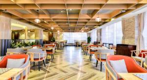 a restaurant with tables and chairs in a room at Atour Hotel Olympic Sports Center Bird's Nest in Beijing