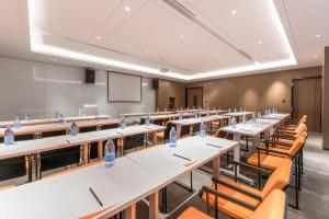 an empty classroom with tables and chairs and a whiteboard at Atour Hotel Zhijiang Bridge in Hangzhou