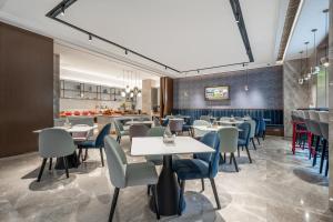 a restaurant with tables and chairs and a bar at Atour X Hotel Shanghai Bund East Nanjing Road Pedestrian Street in Shanghai