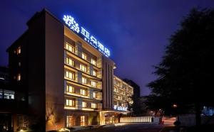 um edifício de hotel com uma placa à noite em Atour Hotel Hangzhou Huanglong em Hangzhou