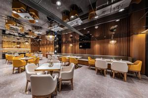 a dining room with tables and yellow chairs at Atour Hotel Shenzhen Baoan Xixiang in Bao'an
