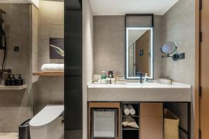 a bathroom with a sink and a toilet and a mirror at Atour Hotel Shanghai Xintiandi Metro Station in Shanghai