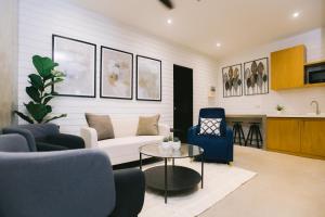 a living room with a couch and chairs and a table at 10 Oxford Residences in Quezon City