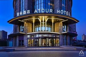 an exterior view of an atrium hotel at night at Atour Hotel Beijing Lishuiqiao in Changping