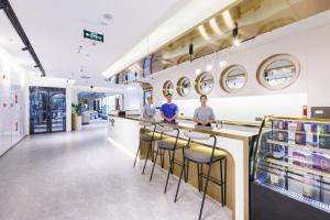 three men standing at a counter in a store at Atour Light Hotel Zhuguang Road Hongqiao National Exhibition and Convention Center in Shanghai
